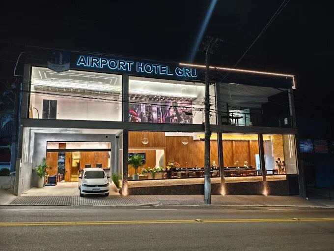 Fachada moderna do AirPort Hotel Gru iluminada ao entardecer